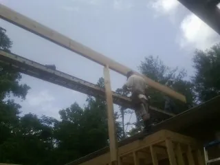 Carpenter setting a ridge beam over a new addition frame — Ice Dam Removal by Roofing Brothers in Pilot Rock