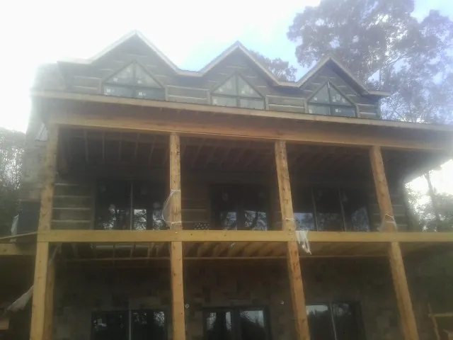 Dormers and porch framing on a large log home under construction — Roof Coating work by our crew in Pilot Rock