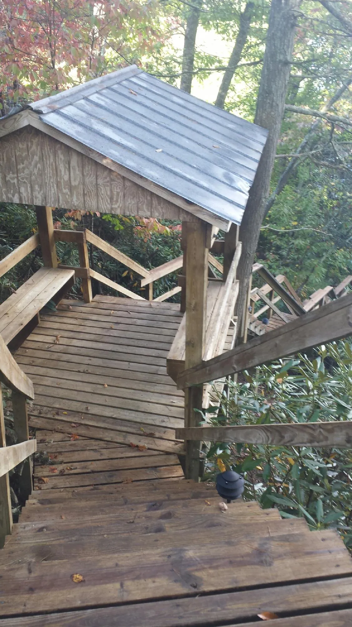 Metal roofed shelter over wooden steps on a wooded walkway — Skylight Repair & Installation work by our crew in Pilot Rock