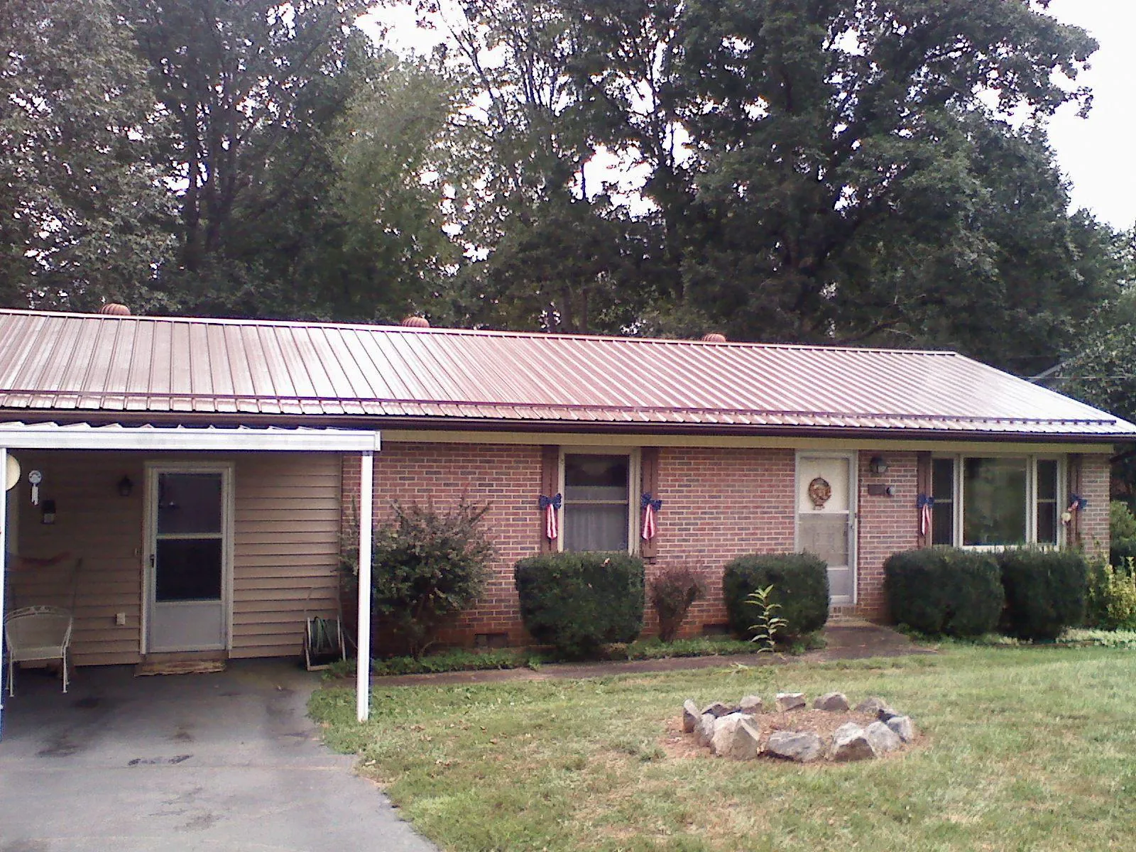 Bronze metal roof and carport on a brick ranch home — Roof Repair work by our crew in Pilot Rock