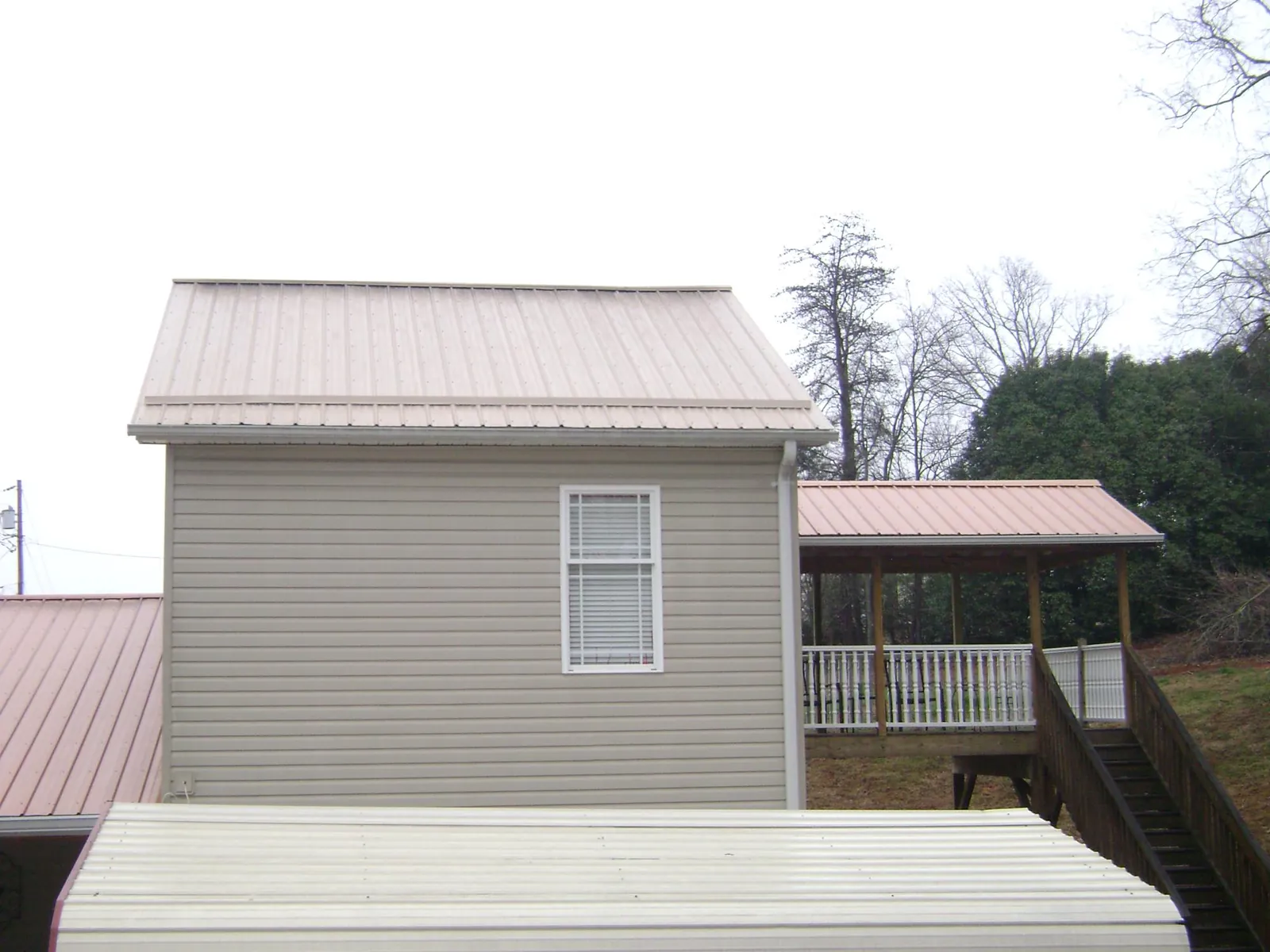 Tan metal roofs on a two story addition and attached porch in Pilot Rock